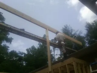 Carpenter setting a ridge beam over a new addition frame — Ice Dam Removal by Roofing Brothers in Hanover